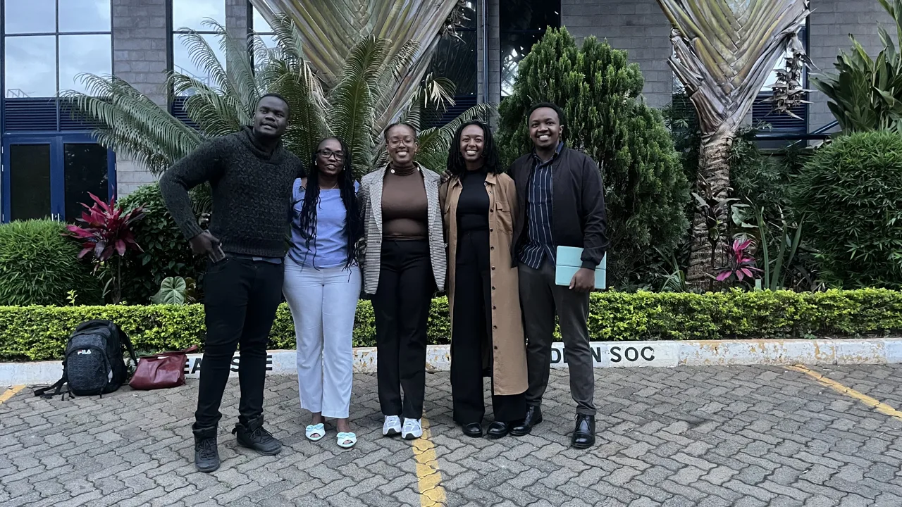 A group of five participants posing outdoors