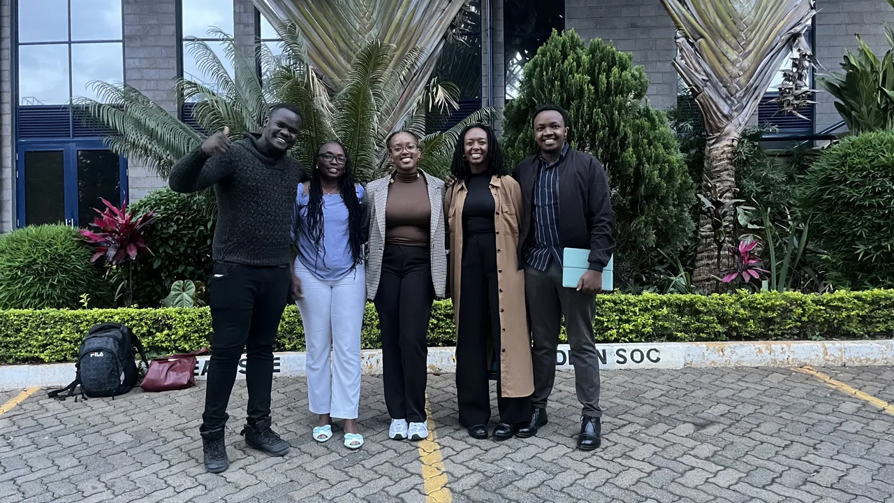 A group of five participants posing outdoors