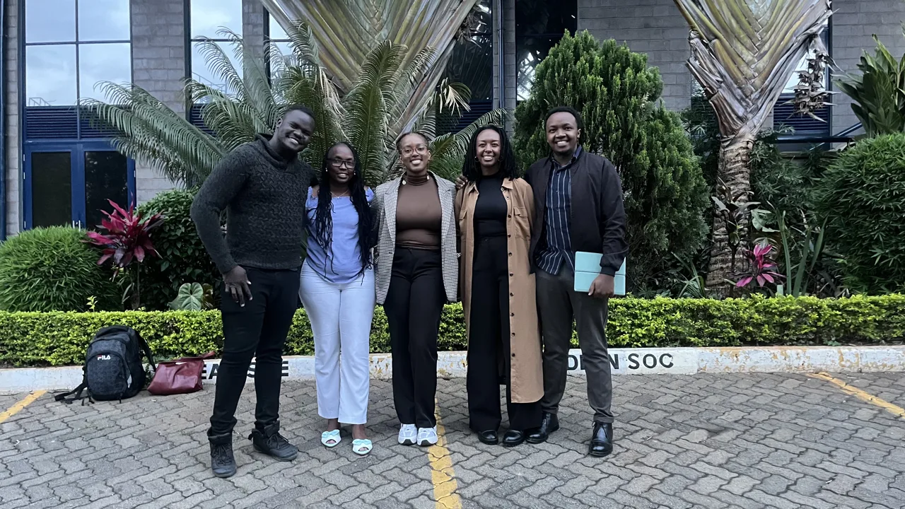A group of five participants posing outdoors