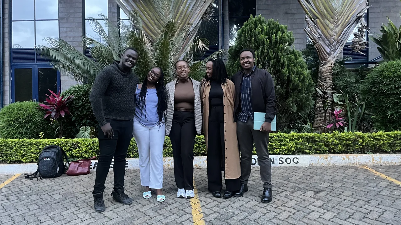 A group of five participants posing outdoors