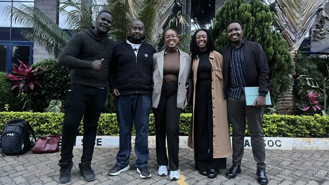 A group of five participants posing outdoors