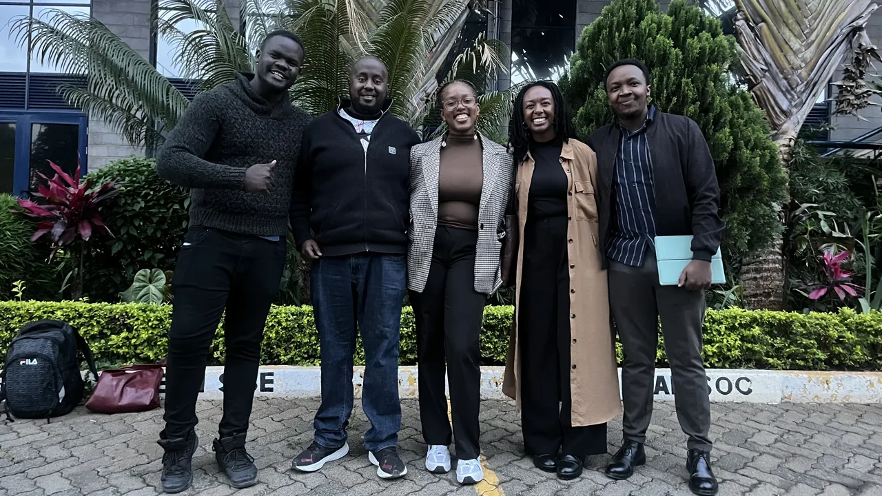 A group of five participants posing outdoors
